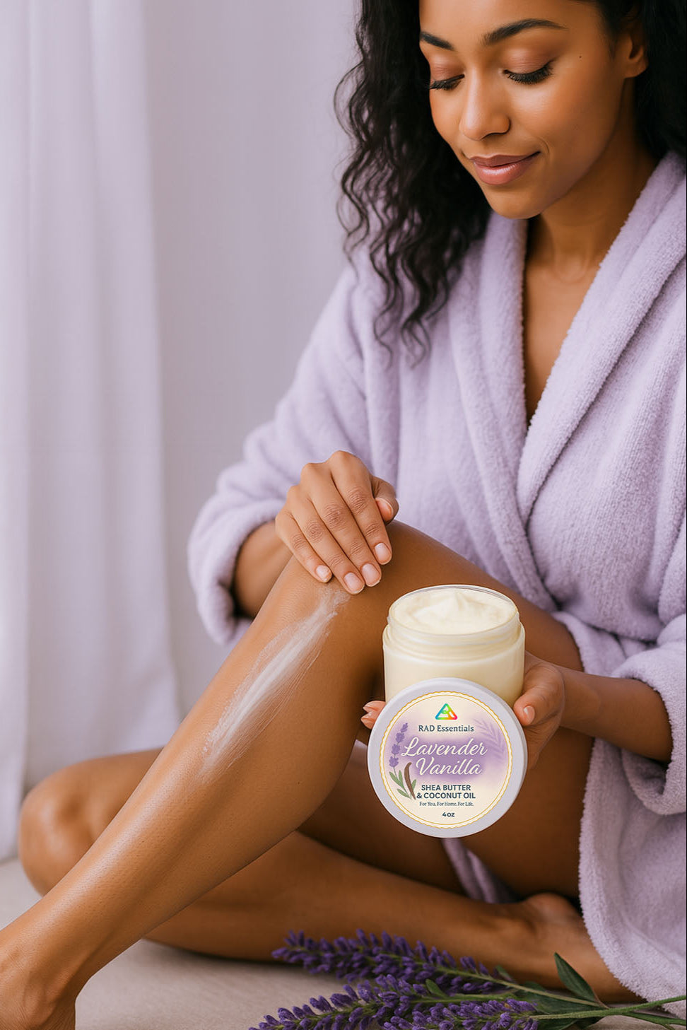 Woman applying lavender body cream to her leg with a jar of the product in front of her.
